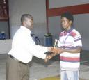 Best lifter Odel Persaud, right, receives his trophy from president of the Guyana Amateur Weightlifting Association (GAWA) Frank Tucker. (Aubrey Crawford photo)