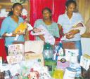 Hameeda Bacchus (centre) and Food for The Poor Representatives Rebecca Seegobin and Bibi Ramkissoon hold Bacchus’ triplets Shahara, Shafeena and Saudia when the charity donated some items to the family.