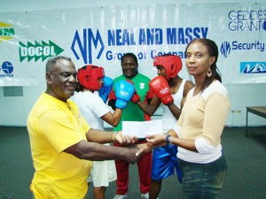 Vice-President of the Guyana Amateur Boxing Association,Rudolph Torrington, left, receives the cheque for sponsorship of the upcoming Independence tournament from Faye Bispham, human resources officer of Neal and Massy.