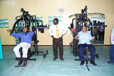 Dr. Frank Anthony and K. Juman Yassin try out the combination fitness machines watched closely by president of the bodybuilding association Frank Tucker while Neil Kumar, at left, opts for the treadmill. (Lawrence Fanfair photos)