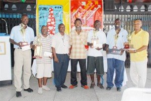 Some of the veteran footballers who turned up yesterday to receive their trophies following the successful completion of the Coca Cola Masters football league. (Clairmonte Marcus photo)