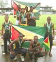TRULY GOLDEN! The Guyana male and female 4×100 relay teams bask under the Golden Arrowhead after producing golden performances in the sprint relays. (Kiev Chesney photo)