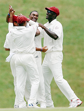Dwayne Bravo is mobbed by his team-mates  after he got the wicket of Phil Jacques. (Cricinfo photo)
