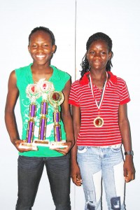 WINSOME DUO! Alika Morgan, (left) and Jenella Jonas with the trophies and medals won at the just-concluded Hampton Games in Trinidad.(Lawrence Fanfair photo)
