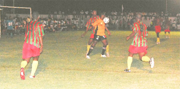 Sunburst Camptown Telson Mc Kinnon controls the ball on his chest whilst being closely marked by Devon Harris during their intense battle in the Sweet 16 final at the Plaisance ground on Monday. Keith Blackman (left) and Shawn Authur (right) rushes in to offer assistance to Harris. (Lawrence Fanfair photo)