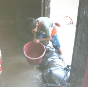 A resident bailing water out of his home on Wednesday afternoon. 
