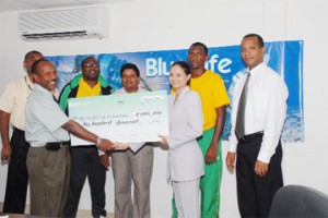 Alicia Katadeen, Sales and Marketing Manager Caribbean International Distributors Incorporated (CIDI), presents the cheque worth $600,000.00 to president of the Guyana Football Federation Colin Klass as from left Frederick Granger, technical director Jamaal Shabazz, Trade Development Officer CIDI Marlon D’ Andrade, Charles ‘Lily’ Pollard (Golden Jaguars captain) and Aubrey Hudson General manager Guyana national team look on admiringly. (Clairmonte Marcus photo).