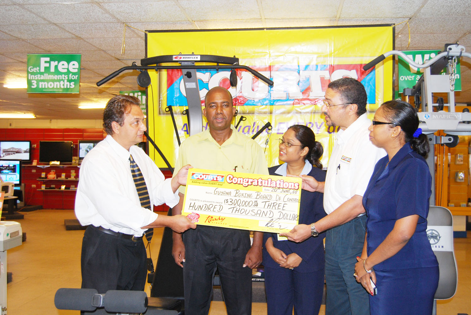 President of the Guyana Boxing Board of Control (GBBC) Peter Abdool (left) receives the cheque from Director of Purchasing and Customer Services (Courts) Clyde de Haas. Looking on appreciatively are from left, Trevor Arno, Zeya Nasir-Ramnauth (Courts PRO) and Molly Hassan (Marketing Executive Courts Guyana Inc. (Lawrence Fanfair photo).