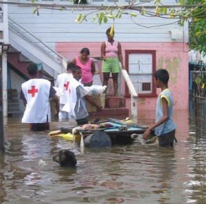 Red Cross volunteers distributing food items to an East Coast Demerara family during the 2005 floods.