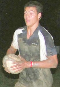 TOUGHING IT OUT! The newest addition to the national under-19 rugby squad, Rupert Giles, goes on a run with the ball in the National Park just hours after his arrival in Guyana from England. (Lawrence Fanfair photo)