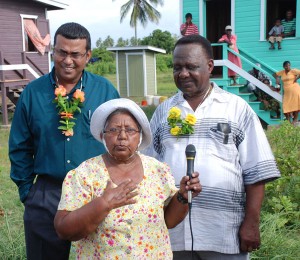 Grass Hook resident Rohani Gopaul expressing gratitude to government for providing free house lots and to Food for the Poor for building 25 houses at Hope Coconut Estate. Also in photo are Food for the Poor Executive Director, Leon Davis (right) and Agriculture Minister Robert Persaud.   (Jules Gibson photo) 