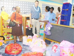 Two staff members of SFCD giving UNICEF Representative, Johannes Wedenig (with garland) and Head of Child Protection at UNICEF, Doris Roos (left) a tour of the Children Friendly Space.