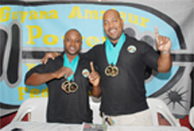 NUMBER ONES ALL THE  WAY!. Mervyn ‘Spongy’ Moses (left) and John ‘Big John’ Edwards strike a pose with their medals for Stabroek Sport photographer Clairmonte Marcus.