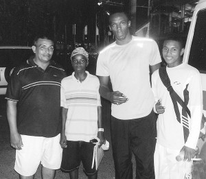 New world 100metres record holder Usain Bolt (second left) strikes a pose with from left John Martins (coach), Calvin Belgrave and Ricardo Martin at the 2008 Hampton Games in Trinidad and Tobago.
