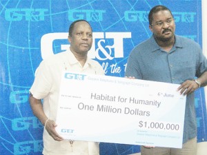 GT&T Deputy General Manager Terry Holder (left) and Habitat for Humanity council member Lance Hinds display a $1M cheque the company donated to the NGO. 