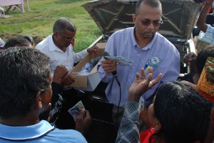 New Guyana Marketing Corporation (GMC) General Manager Nizam Hassan handing out packets of vegetable seeds to Mahaica River farmers. (Jules Gibson photo) 