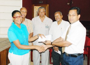Reginald Persaud (right) of the Institute of Private Enterprise Development presents a cheque to Cathy Hughes