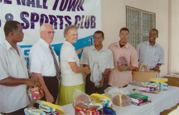 Sister Bullock of the Church of Jesus Christ of Latter Day Saints hands over the sports gear to Karl Xavier representative of the Corentyne Comprehensive High School.