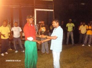 Chris Barnwell receives his man of the match trophy from Anand Sanasie, president of the West Demerara Cricket Association. (Photo by Calvin Roberts)