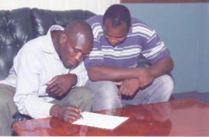 SIGN ON THE DOTTED LINE! Denny Dalton signs the Guyana Boxing Board of Control’s contract to fight on the board’s upcoming Judgement Day card. 