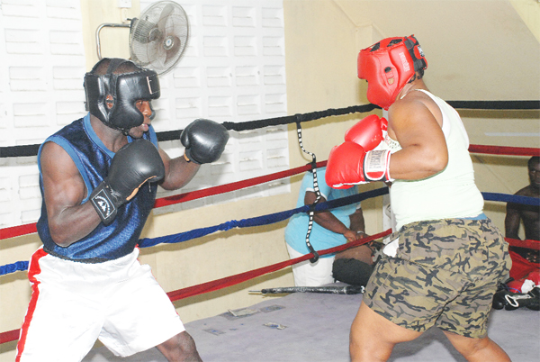 ‘Deadly’ Denny Dalton is caught in an intense sparring session with Guyana’s female heavyweight champion Pamela London at the Andrew ‘Six Head’ Lewis gym yesterday afternoon. (Clairmonte Marcus photo)