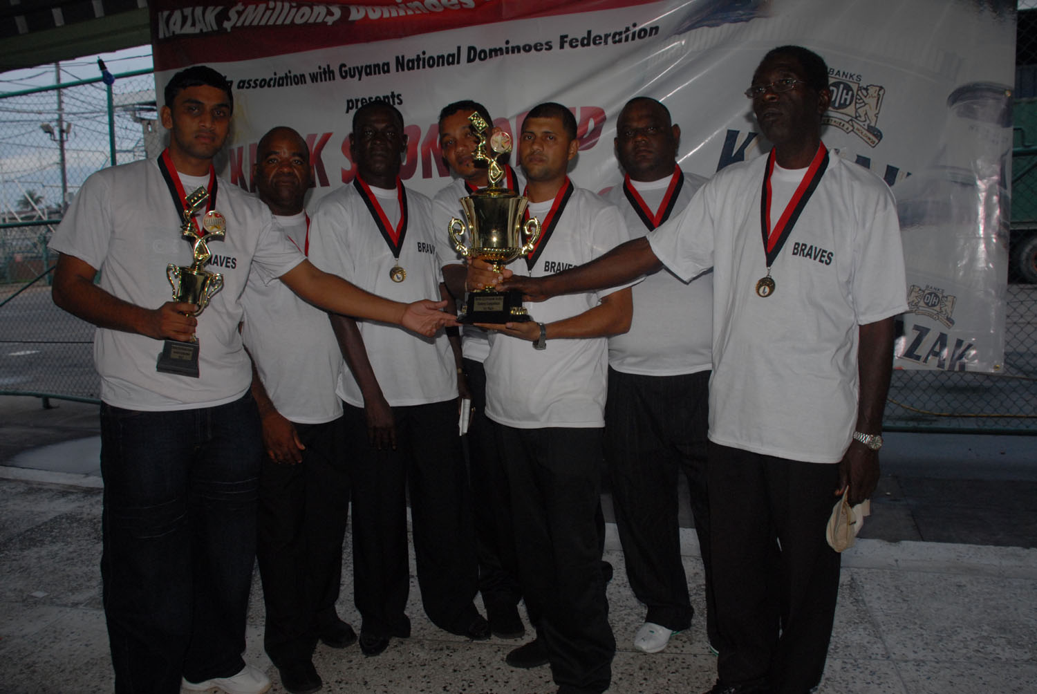 The Braves  pose with their medals and the 2008 Banks DIH-sponsored Kazak Dominoes Trophy. At left is finals MVP Ganesh Sankar with his spoils. (Clairmonte Marcus photo)