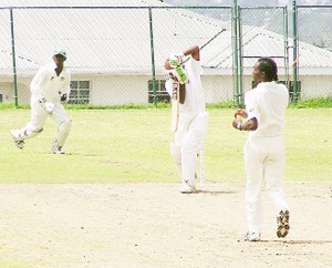 Adrian Barath plays a defensive shot to a Leon Scott delivery as wicket-keeper Anthony Bramble looks on.