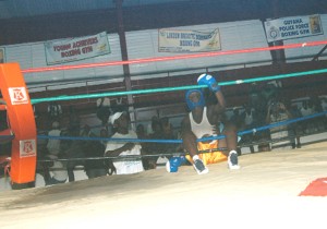 WHERE AM I? Sherwin Clarke of Republican Gym holds onto the ropes to prevent himself falling completely out of the ring after he was knocked through the ropes by Guyana Defence Force’s Mark Pierre (not in picture) on the final night of the Gaskin and Jackson National Open Boxing Championship at the National Gymnasium. (Aubrey Crawford photo)