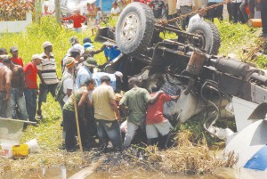 Rescuers trying feverishly yesterday to extricate the injured man from the truck. (Jules Gibson photo)