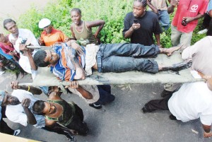 Public-spirited citizens lifting Imran Hassan to the ambulance after he was freed from under the truck after a rescue operation that lasted two hours. (Jules Gibson photo)  