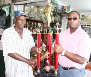 Mortimer Stewart – Banks DIH Special Events Manager (right) presents the Feature Event Trophy to Compton Sancho, Organising Secretary of the Norman Singh Memorial Turf Club.