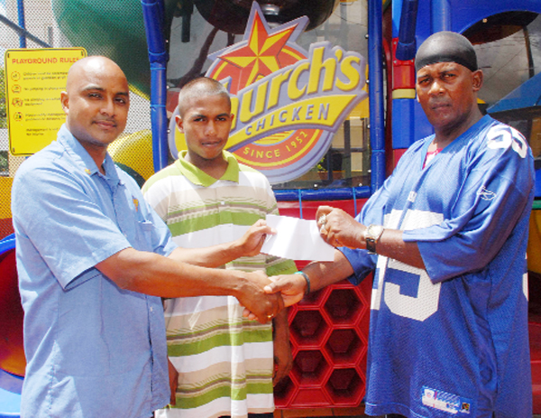 In this Clairmonte Marcus photo, Church’s Restaurant director Gregory De Gaans hands over the cheque to president of Flying Ace Cycle Club in New Amsterdam, Randolph Roberts. At centre is national junior road race champion Neil Reece.