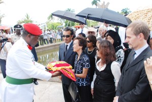 The flag that had been draped over the former president’s casket during yesterday’s funeral service is handed over to his wife Doreen at the Seven Ponds. (Jules Gibson photo).