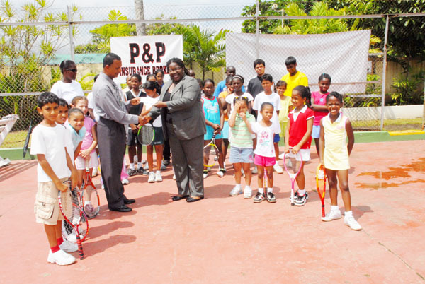 Managing Director of P&P Insurance Brokers Bishnu Panday hands over the sponsorshipcheque to GLTA’s secretary Grace McCalman as camp instructor Shelly Daly stands at rear (left) among the young, eager participants.(Clairmonte Marcus photo)