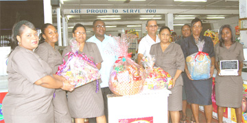 In picture Inspector Persaud and Sgt. Cadogan along with other members of staff of the Co-op Society display some of the hampers and other gifts that will be given away to shoppers
