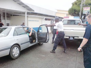 Two of the UK cops (at right and in car) and GPF members go through the paces. (British High Commission photo)