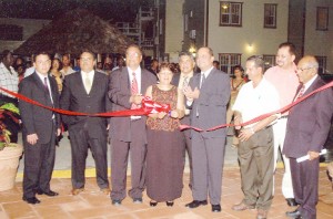 Sita Shewnarain (centre), owner and director of the Aracari Resort cuts the ribbon to officially open the resort last Thursday. Assisting her is her husband, Sase Shewnarain while Minister of Tourism, Industry and Commerce, Manniram Prashad (fourth from right) looks on in the presence of other guests.  