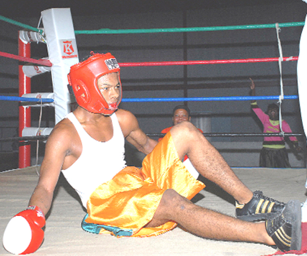 STUNNED!! Edwin Jones tries to recuperate after a sharp left hook from Roy Franker (not in picture) sent him to get acquainted with the canvas Monday evening at the National Gymnasium. (Clairmonte Marcus photo)