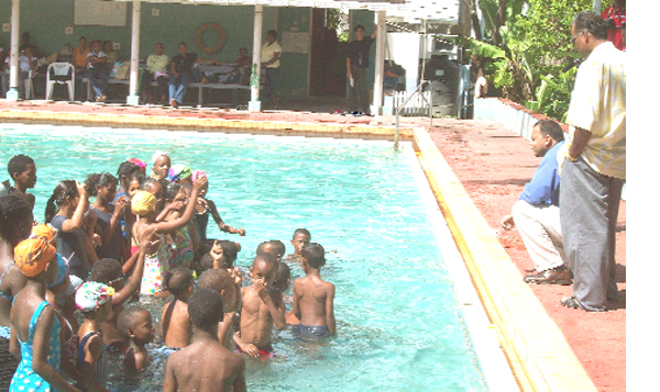 Minister of Culture, Youth and Sport, Dr Frank Anthony (stooping) gives the participants of this year’s swim camp which began on Wednesday and was officially declared open by him yesterday at the Colgrain Pool a pep talk. Standing next to Dr Anthony is Director of Sport Neil Kumar.