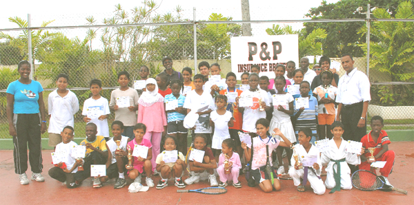  The awardees of the GLTA 2008 Tennis Summer Camp pose with their medallions, trophies and certificates at the conclusion of their programme at the Le Meridien Pegasus Tennis Court with Managing Director of P&P Insurance Brokers, Bish Panday, standing at far right and Instructor Shelly Daly (extreme left). (Clairmontev Marcus photo)