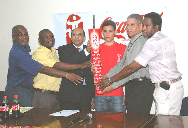 Torch touching: (from right) President of the Guyana Cycling Federation Hector Edwards, Sales and Marketing Manager of Banks DIH Carlton João, Niall Roberts, President of the GOA K.A Juman Yassin, Communications Officer of Banks DIH Troy Peters and President of the AAG Claude Blackmore all touch the torch that will be carried this Saturday at the Coca Cola Torch relay. (A Clairmonte Marcus Photograph)  