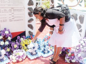 Zahira Zakir, the widow of Lance Corporal, Zaheer Zakir lays a wreath in his memory at the Guyana Police Force ceremony at Eve Leary yesterday. He was killed in the February 17 Bartica massacre.   