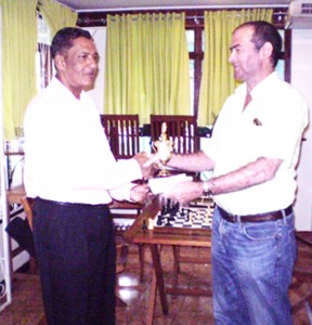 Tiwari receiving the winner’s cheque and trophy from William Walker, proprietor of Oasis Cafe