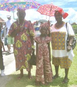 A lass, resplendent in her maroon-coloured African outfit, attends Emancipation Day activities with her relatives. 