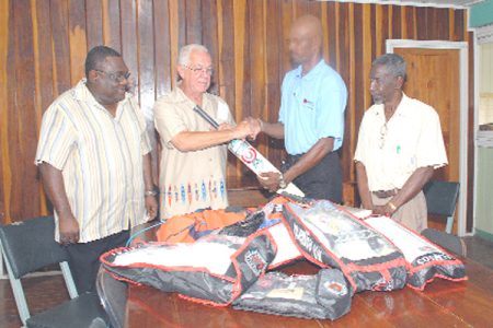 Joseph ‘Reds’ Perriera presents a piece of the cricket kit he donated to the Martindale School in Pomeroon, Essequibo to President of the Essequibo Cricket Board Alvin Johnson while  Chairman of the Senior Selectors of the GCB Claude Raphael (far left) and Vice President of the GCB look on. 