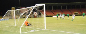 Strike one of three: Suriname’s Captain Marlon Felter (second right) made no mistake in converting this penalty kick which was the first of three goals scored by his team against Dominica last night at Providence in the group stage of the Digicel Caribbean Championships. (Photo by Lawrence Fanfair)  