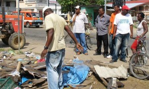 Regional officials, from left to right (in background), Floyd France, REO; Karran P. Deokarran, vice chairman and Govind Singh, RDO (in red cap) look on as the debris was being removed.