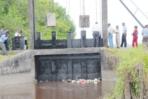Agriculture Minister Robert Persaud inspecting the newly installed sluice door. (Clairmont Marcus photo) 