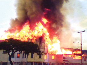 The fire spreading to the building housing the Medical Outpatient Department and the Patient Care Assistance (PCA) teaching facility. The male observation ward where the fire started had already been gutted. (Trevoll Pereira photo)