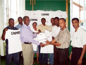 President of the Georgetown Cricket Association (GCA) Bish Panday presents one of the shirts to  Grantley Culbard of the Georgetown Cricket Umpires and Scorers Association (GCUSA) as other executives of both organizations look on.